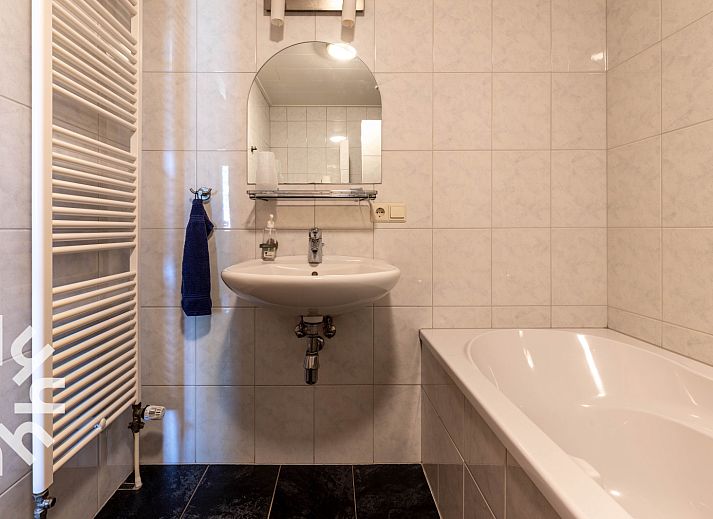 Modern bathroom in DG025 vacation home, Didam, with bathtub and sink.