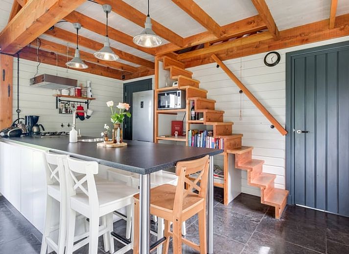 Geraeumiges Wohnzimmer im Ferienhaus in Zutphen, Achterhoek, mit freiliegenden Holzbalken und modernen Moebeln.