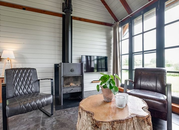 Geraeumiges Wohnzimmer im Ferienhaus in Zutphen, Achterhoek, mit freiliegenden Holzbalken und modernen Moebeln.