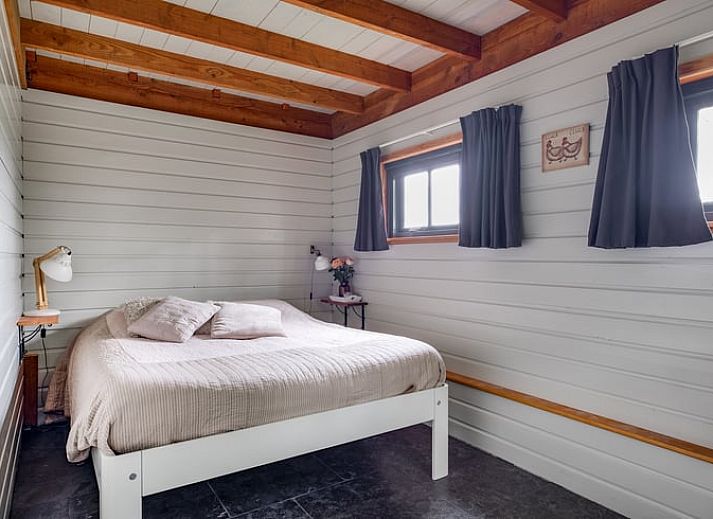 Geraeumiges Wohnzimmer im Ferienhaus in Zutphen, Achterhoek, mit freiliegenden Holzbalken und modernen Moebeln.