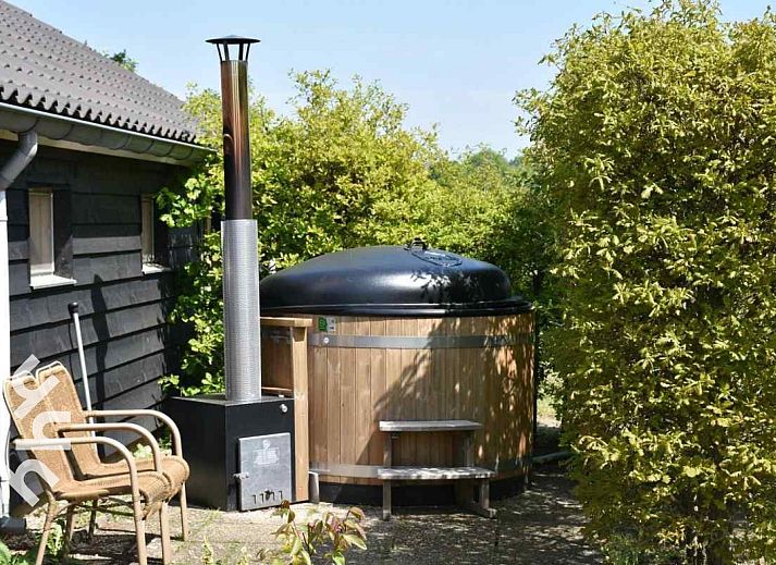 Ruhiger Garten des Ferienhauses DG126 in Vorden, Achterhoek, Gelderland mit Terrasse und Baeumen.
