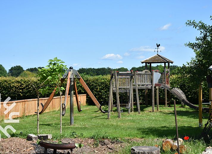 Ruhiger Garten des Ferienhauses DG126 in Vorden, Achterhoek, Gelderland mit Terrasse und Baeumen.