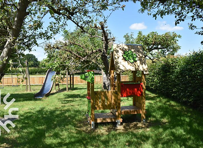 Ruhiger Garten des Ferienhauses DG126 in Vorden, Achterhoek, Gelderland mit Terrasse und Baeumen.