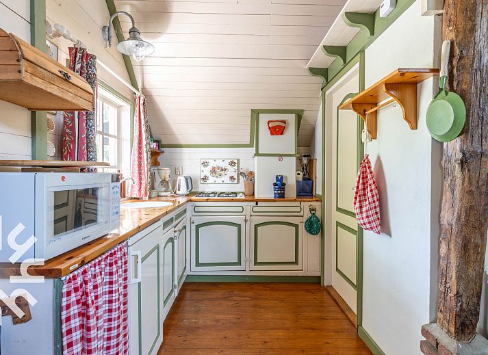 Terrace at vacation home DG496 in Vorden, Achterhoek, overlooking green fields.