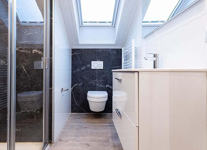 Comfortabele slaapkamer in Villa 12 personen Wellness, Lichtenvoorde met groot raam en kunstwerk.