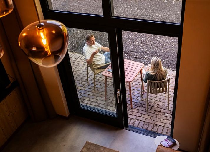 Gezellige binnenruimte van Vakantiehuisje in Neede, Achterhoek, met houten interieur en comfortabele zithoek.