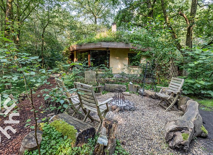 Schlafzimmer des Ferienhauses DG1417 in Neede, Achterhoek mit Holzdecke und Blick auf die gruene Umgebung.