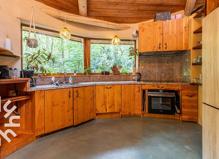 Schlafzimmer des Ferienhauses DG1417 in Neede, Achterhoek mit Holzdecke und Blick auf die gruene Umgebung.