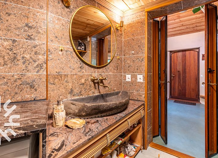 Schlafzimmer des Ferienhauses DG1417 in Neede, Achterhoek mit Holzdecke und Blick auf die gruene Umgebung.