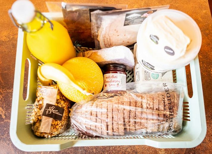 Gezellige woonkamer in Vakantiehuisje in Neede, Achterhoek, met moderne keuken en houten trap.