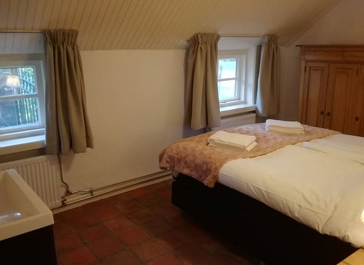 Ruime eetkamer in Vakantiehuis in Gaanderen, Achterhoek, Gelderland, met houten balken en lange tafel.