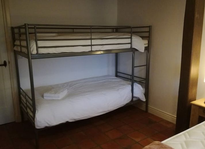 Gezellige woonkamer in Vakantiehuis in Gaanderen, Achterhoek, Gelderland, met comfortabele zithoek en houten plafond.