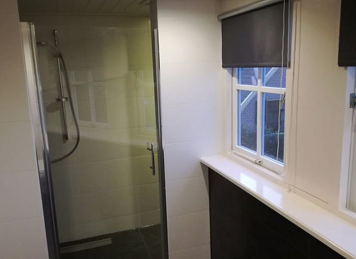 Gezellige woonkamer in Vakantiehuis in Gaanderen, Achterhoek, Gelderland, met comfortabele zithoek en houten plafond.