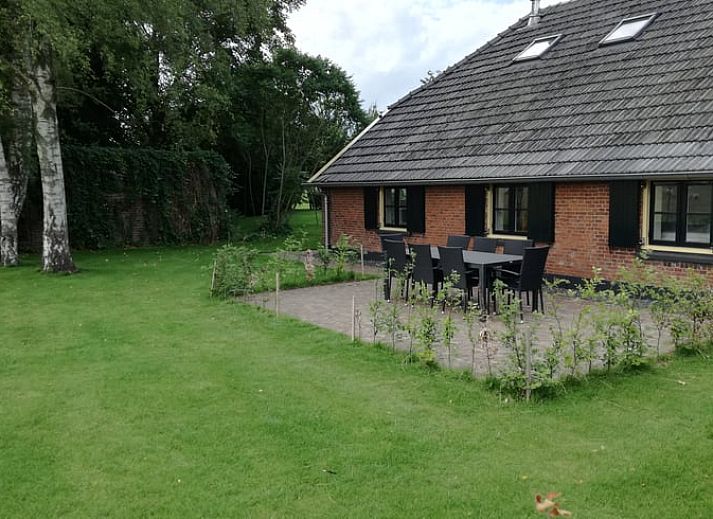 Eetgedeelte in Vakantiehuis in Gaanderen, Achterhoek, Gelderland, met grote houten tafel en uitzicht op de tuin.