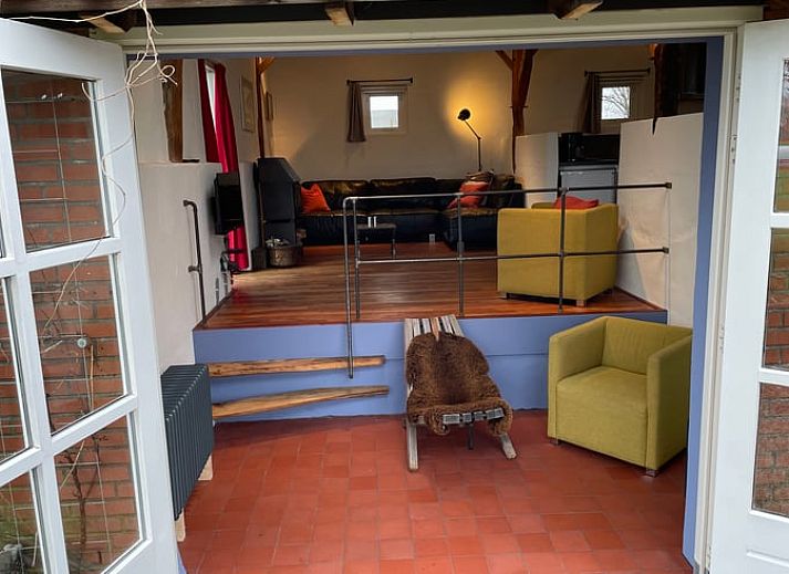 Cozy outdoor area of cottage in Lievelde, Achterhoek, with hanging chairs and covered terrace for a relaxing stay in Gelderland.