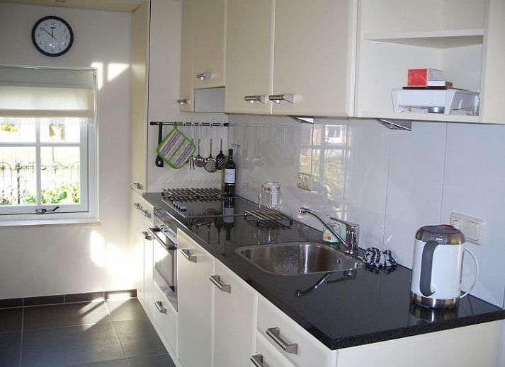 Terras van WegInWinterswijk vakantiehuis in Winterswijk, Achterhoek met parasol en zitplaatsen in de tuin.