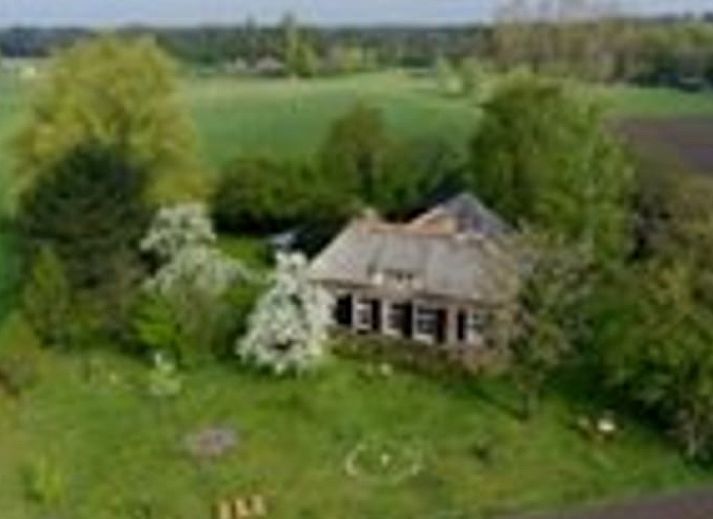 View of the vast fields surrounding Cottage in Warnsveld, Achterhoek, with grazing horses.