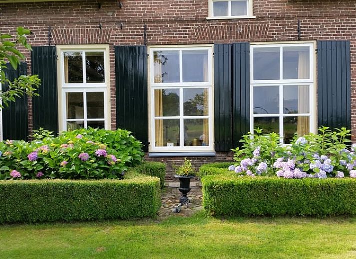 Cozy bedroom in Cottage in Warnsveld, Achterhoek, with colorful blankets and bedside tables.