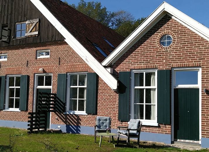 Ferienhaus in Winterswijk Woold mit traditioneller Backsteinfassade und gruenen Fensterlaeden, gelegen in Achterhoek, Gelderland.