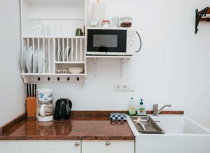 Ruime binnenruimte met houten trap in Vakantiehuis in Winterswijk Woold, perfect voor een ontspannen verblijf in de Achterhoek.