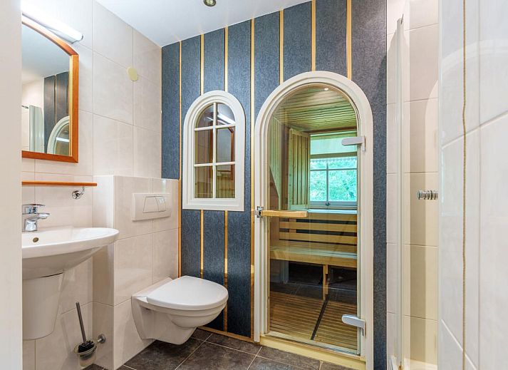 Gemuetliches Wohnzimmer im Ferienhaus de Spil, Winterswijk Meddo, mit bequemem Ecksofa und Kamin.