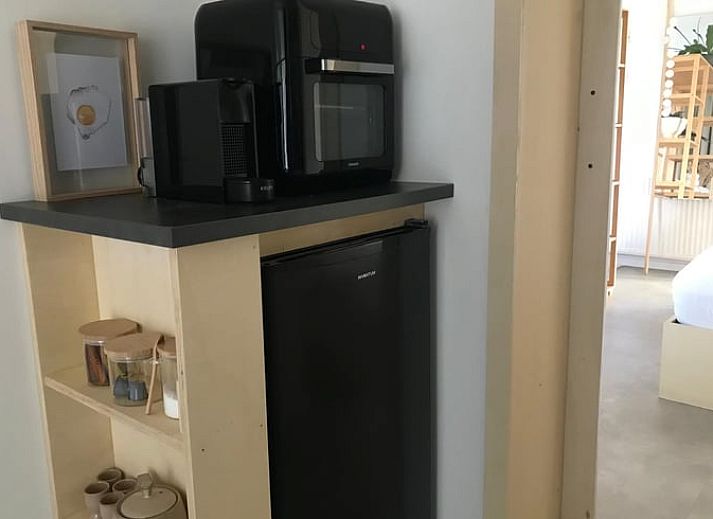 Gezellig terras bij Vakantiehuis in Baak, Achterhoek, omringd door bloemen en houten afwerking.