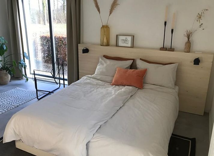 Gezellig terras bij Vakantiehuis in Baak, Achterhoek, omringd door bloemen en houten afwerking.