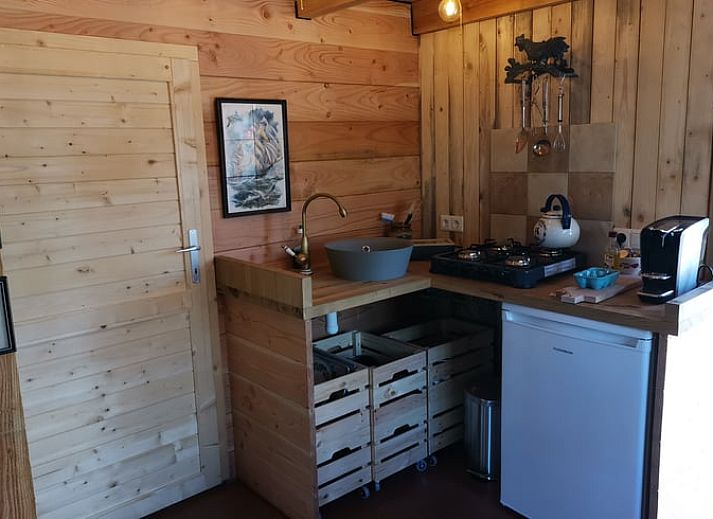 Gemuetliches Interieur des Ferienhauses in Winterswijk Corle mit Holzinterieur und farbenfrohen Stuehlen, gelegen in Achterhoek, Gelderland.