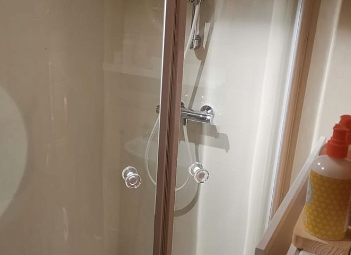 Gemuetlicher Innenbereich des Ferienhauses in Winterswijk Corle, gelegen in Achterhoek, Gelderland, mit Holzinterieur und Blick auf die Terrasse.