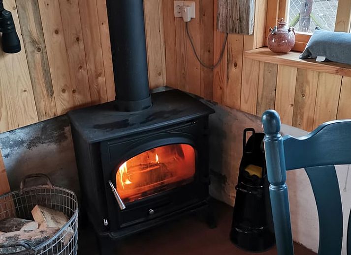 Gemuetlicher Innenbereich des Ferienhauses in Winterswijk Corle, gelegen in Achterhoek, Gelderland, mit Holzinterieur und Blick auf die Terrasse.