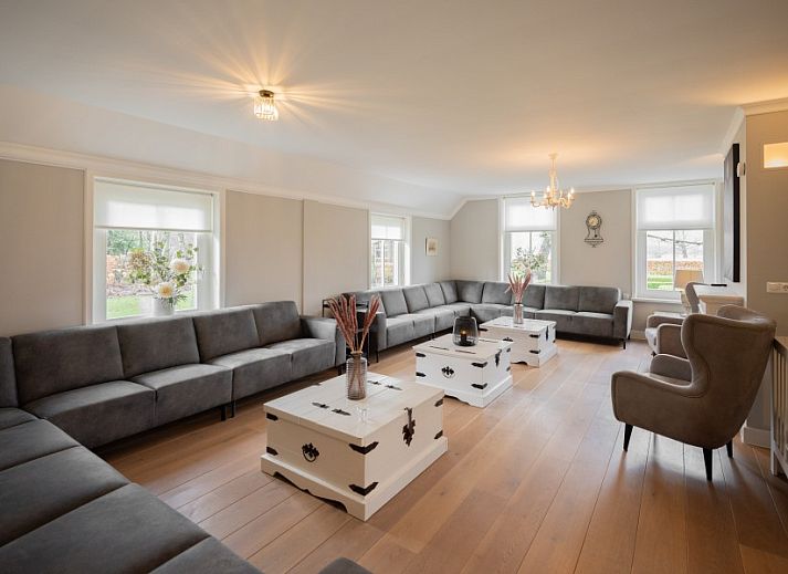 Gezellige zithoek in de tuin van Groepsaccommodatie Dickenes, Bennekom, Veluwe, omgeven door groen.