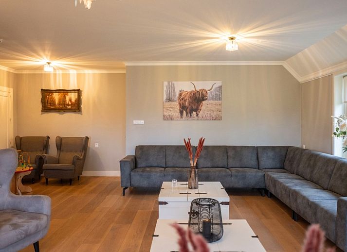 Gezellige zithoek in de tuin van Groepsaccommodatie Dickenes, Bennekom, Veluwe, omgeven door groen.