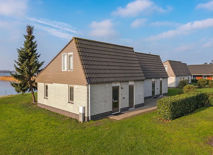 Der Bungalow Comfort Deluxe in Elburg, Gelderland, bietet einen schoenen Blick auf den See und die gruene Umgebung.