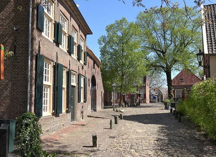 Cozy bedroom in Cottage in Bronkhorst, vacation home in Gelderland, with comfortable bed and artistic wall decoration.