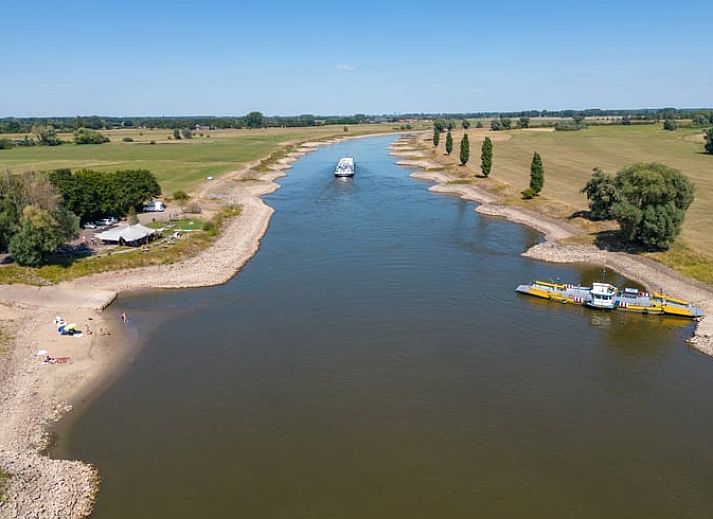 Dining area in Cottage in Bronkhorst, vacation home in the valley of Gelderland, with wooden table and view of nature.