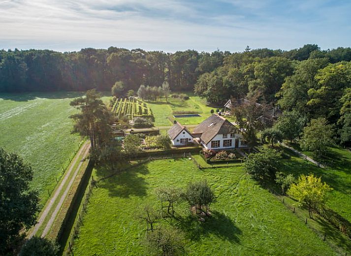 Luchtfoto van Huisje in Empe, vakantiehuis in Gelderse vallei, omgeven door groene velden en bossen.