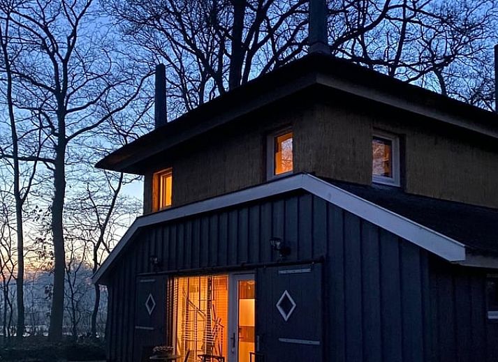 Charmant exterieur van Huisje in Empe, vakantieverblijf in Gelderland, omgeven door bomen.