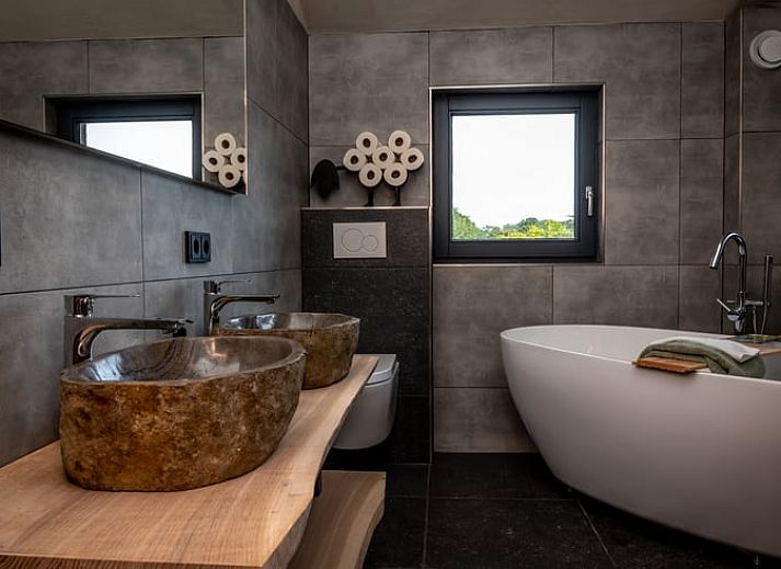 Charmant exterieur van Huisje in Empe, vakantieverblijf in Gelderland, omgeven door bomen.