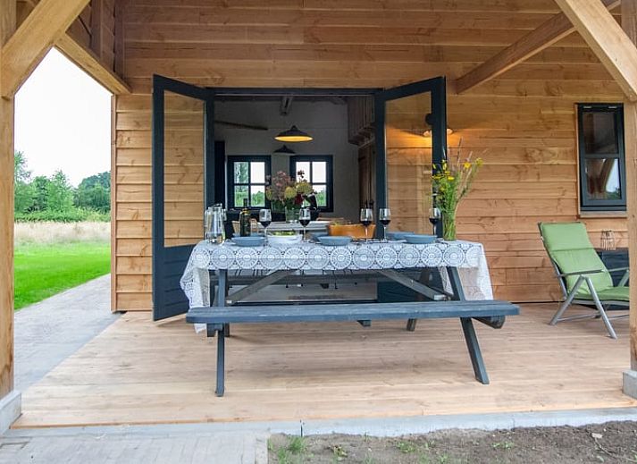 Gezellige eetruimte van Vakantiehuis in Empe, Gelderse vallei, met uitzicht op groene natuur en sfeervolle houtkachel.