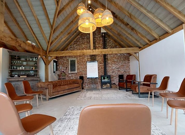 Sfeervol verlicht terras bij Huisje in Tonden, vakantiehuis in de Gelderse vallei, omringd door natuur en kleurrijke bloemen.