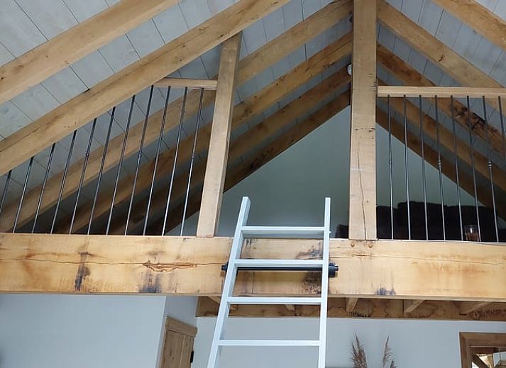 Gezellige slaapkamer van Huisje in Tonden, vakantiehuis in de Gelderse vallei, met warme verlichting en uitzicht op de natuur.