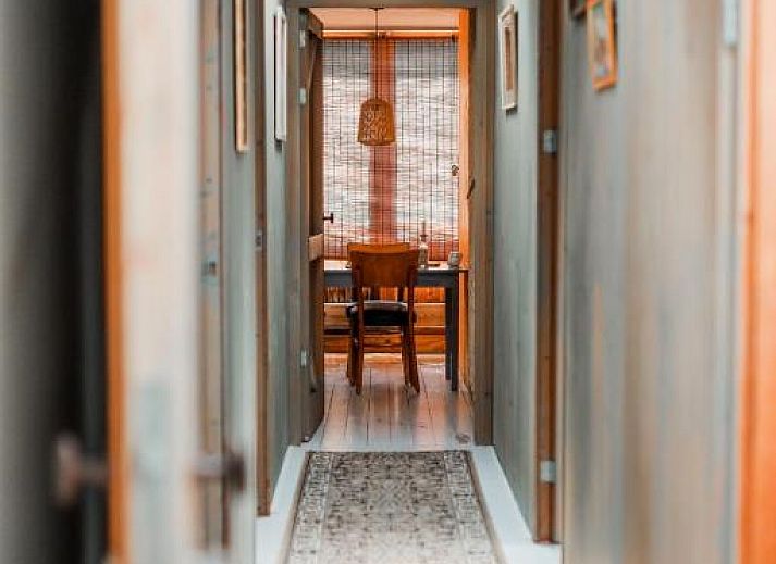 Attraktives Schlafzimmer in In de Aap - Apartments & Guesthouse, Bergen, Nordholland, mit rustikalen Holzbalken und bequemen Betten.