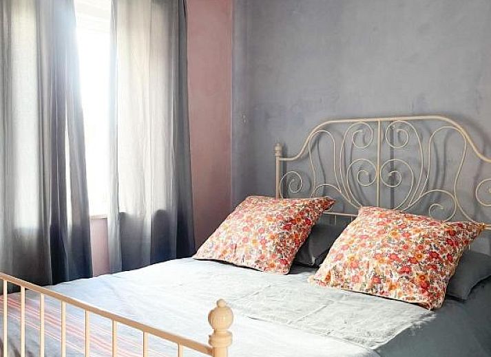 Attraktives Schlafzimmer in In de Aap - Apartments & Guesthouse, Bergen, Nordholland, mit rustikalen Holzbalken und bequemen Betten.