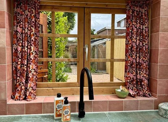 Heller Essbereich im In de Aap - Apartments & Guesthouse, Bergen, Nordholland, mit Glasdach und farbenfrohem Dekor.