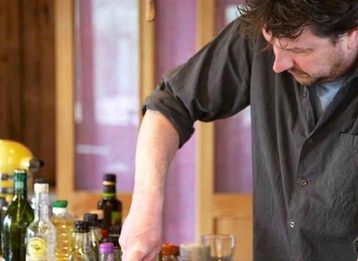 Charmanter Aussenbereich von In de Aap - Apartments & Guesthouse in Bergen, Nordholland, mit bunten Stuehlen und bluehenden Pflanzen.