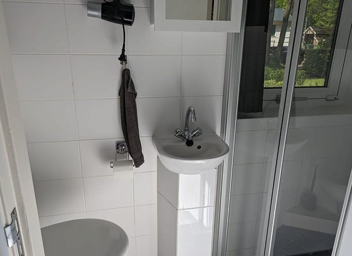 Gemuetliches Wohnzimmer des Ferienhauses in Beekbergen, Ferienhaus in der Veluwe in Gelderland, mit komfortabler Sitzecke und Essbereich.