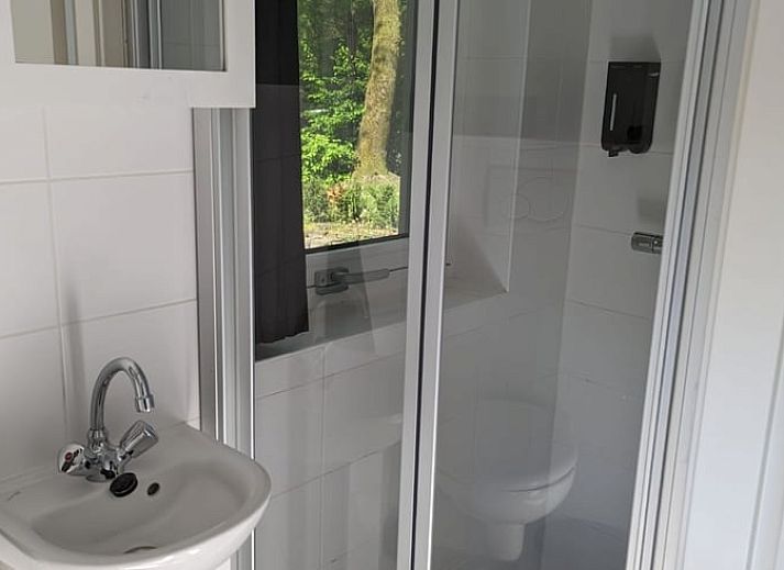 Gemuetliches Wohnzimmer des Ferienhauses in Beekbergen, Ferienhaus in der Veluwe in Gelderland, mit komfortabler Sitzecke und Essbereich.