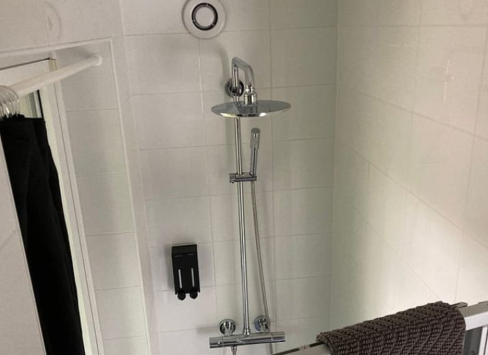 Gemuetliches Wohnzimmer des Ferienhauses in Beekbergen, Ferienhaus in der Veluwe in Gelderland, mit komfortabler Sitzecke und Essbereich.