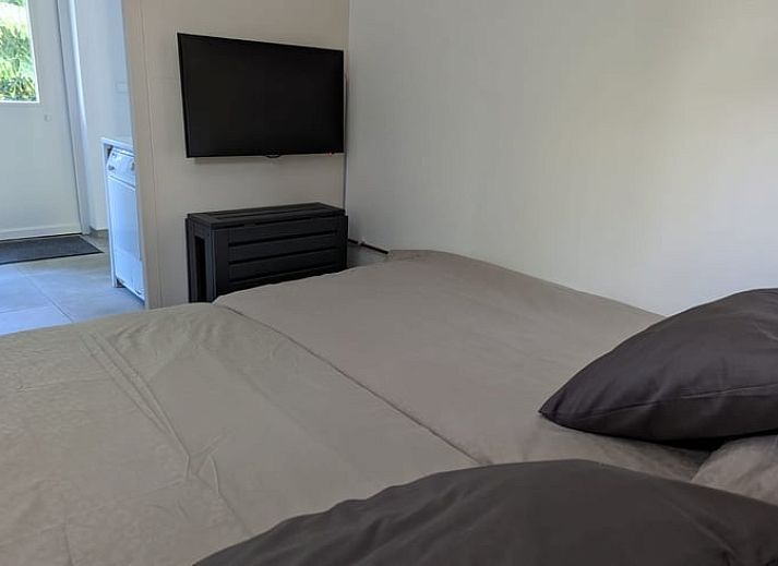 Gemuetliches Wohnzimmer des Ferienhauses in Beekbergen, Ferienhaus in der Veluwe, Gelderland, mit komfortabler Sitzecke und modernem Kamin.