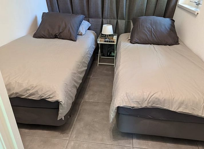 Gemuetliches Wohnzimmer des Ferienhauses in Beekbergen, Ferienhaus in der Veluwe, Gelderland, mit komfortabler Sitzecke und modernem Kamin.